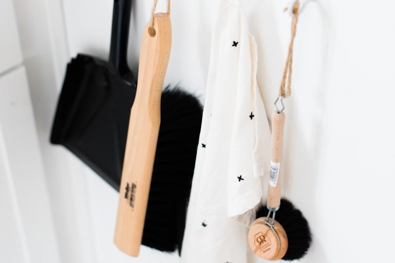 three black and brown bathroom cleaning tools